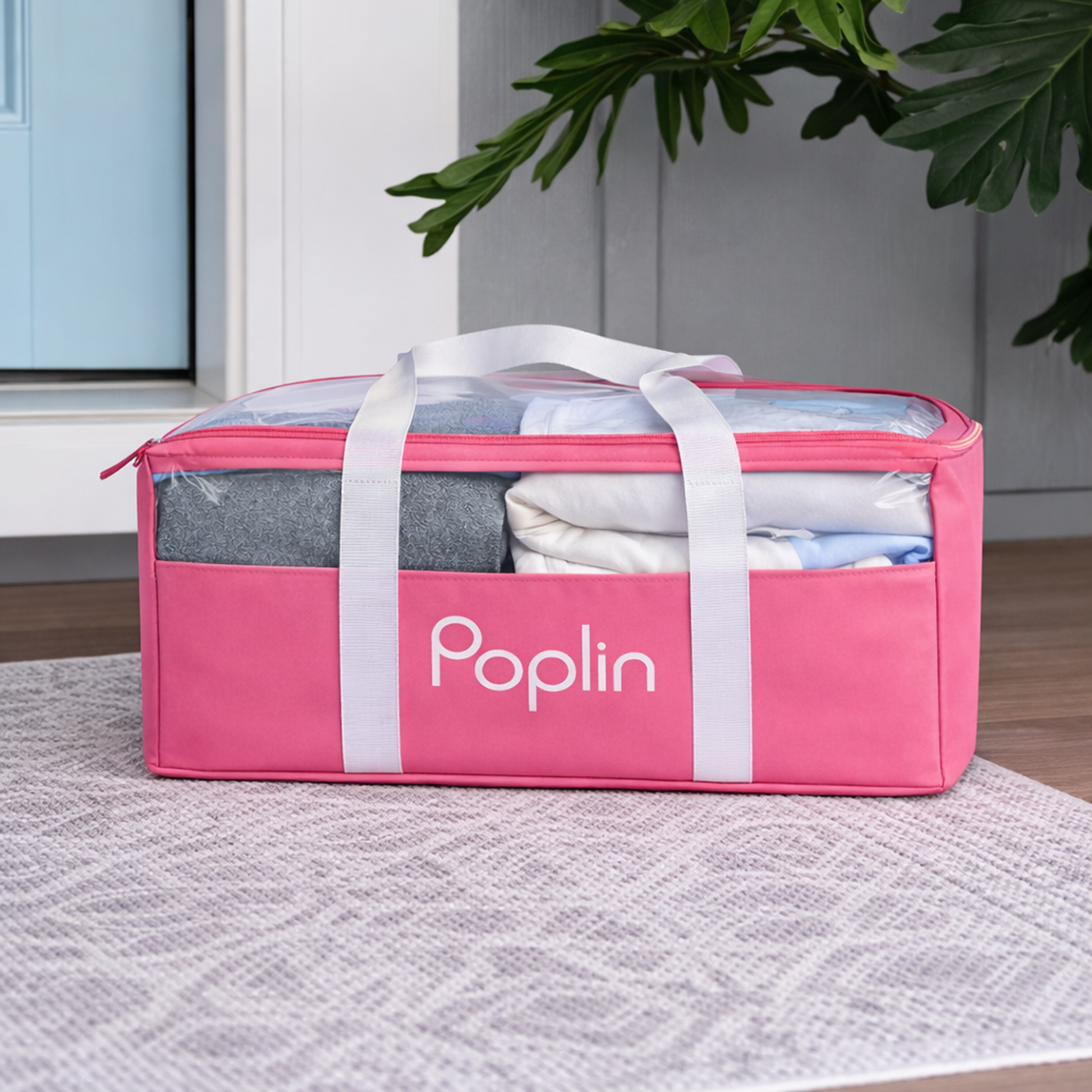 Pink Poplin delivery bag filled with neatly folded laundry, zipped closed, placed on a front porch with natural light and greenery.
